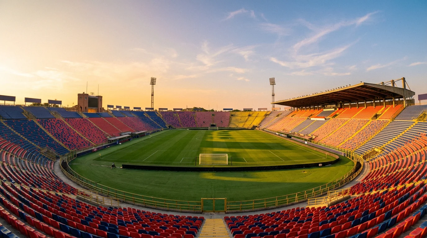 Panoramica di uno stadio italiano con il campo da calcio illuminato prima di una partita serale